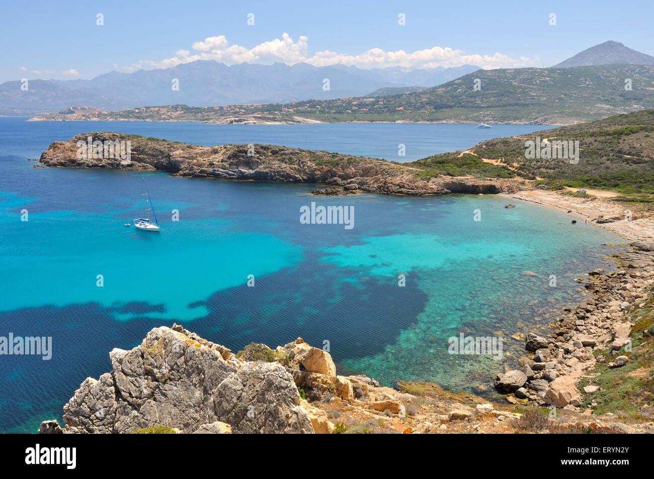 Bateau sur l'eau turquoise entourée de falaises - Corse Banque D'Images