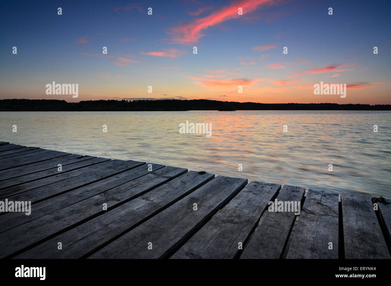 Petite jetée en bois sur grand lac au coucher du soleil en Ukraine Banque D'Images