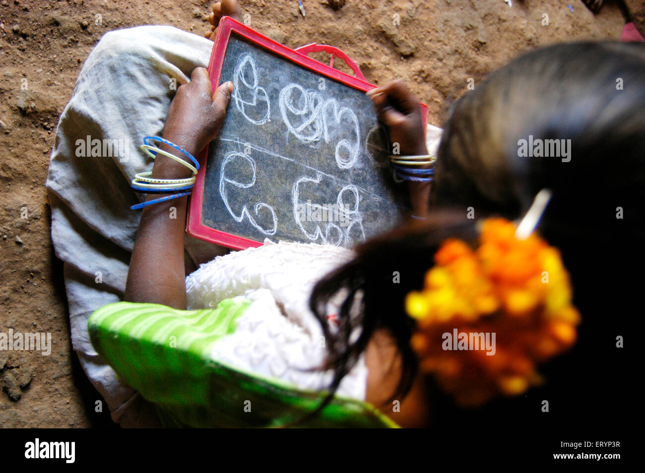 Apprendre le télougou fille Tribal alphabets dans école dirigée par ONG Organisation non gouvernementale dans le village à l'Andhra Pradesh en Inde ; Banque D'Images