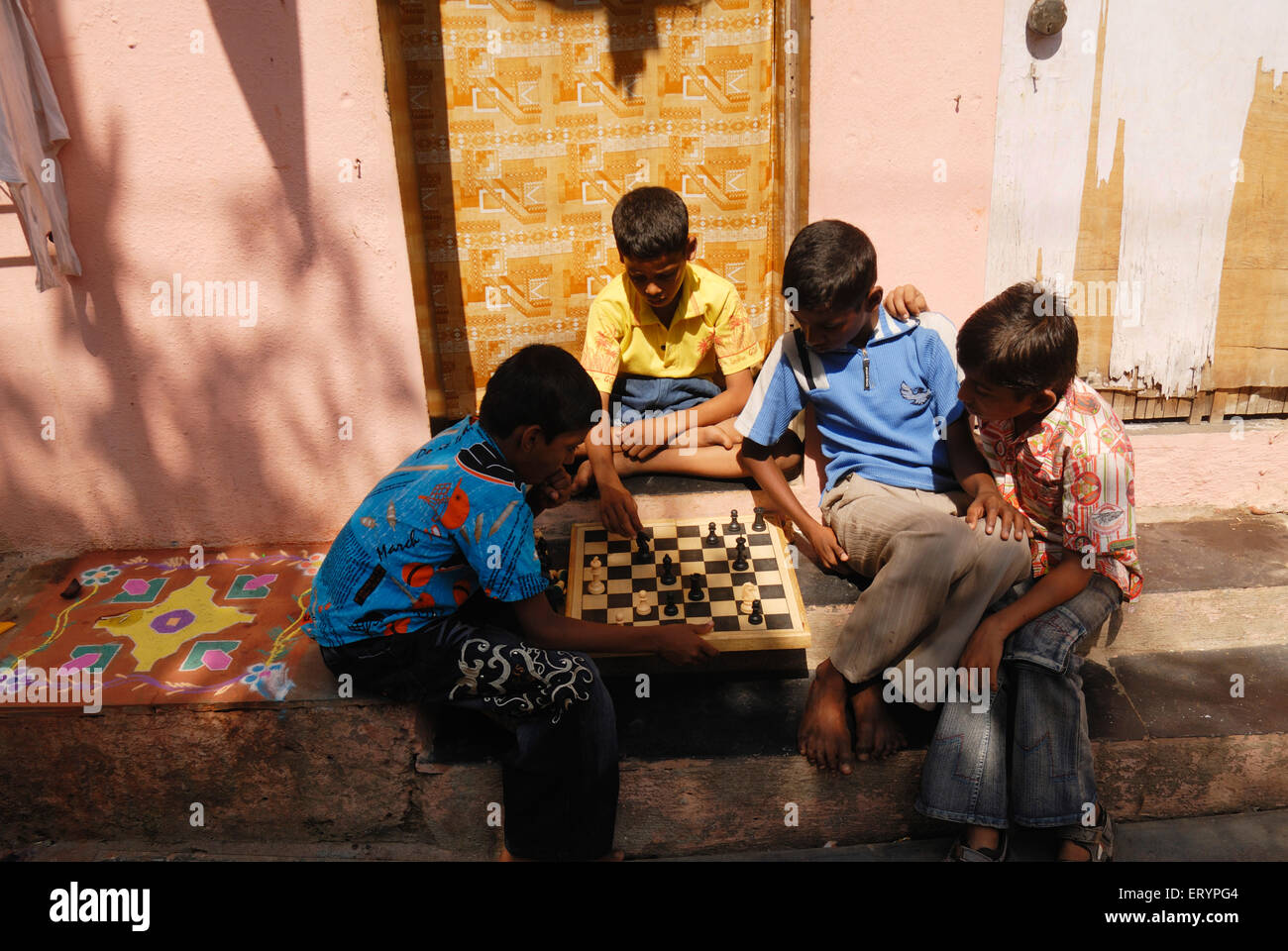 Les enfants de l'école jouer aux échecs pendant leurs vacances à l'extérieur de leur maison à Bombay Mumbai Maharashtra ; Inde ; Banque D'Images