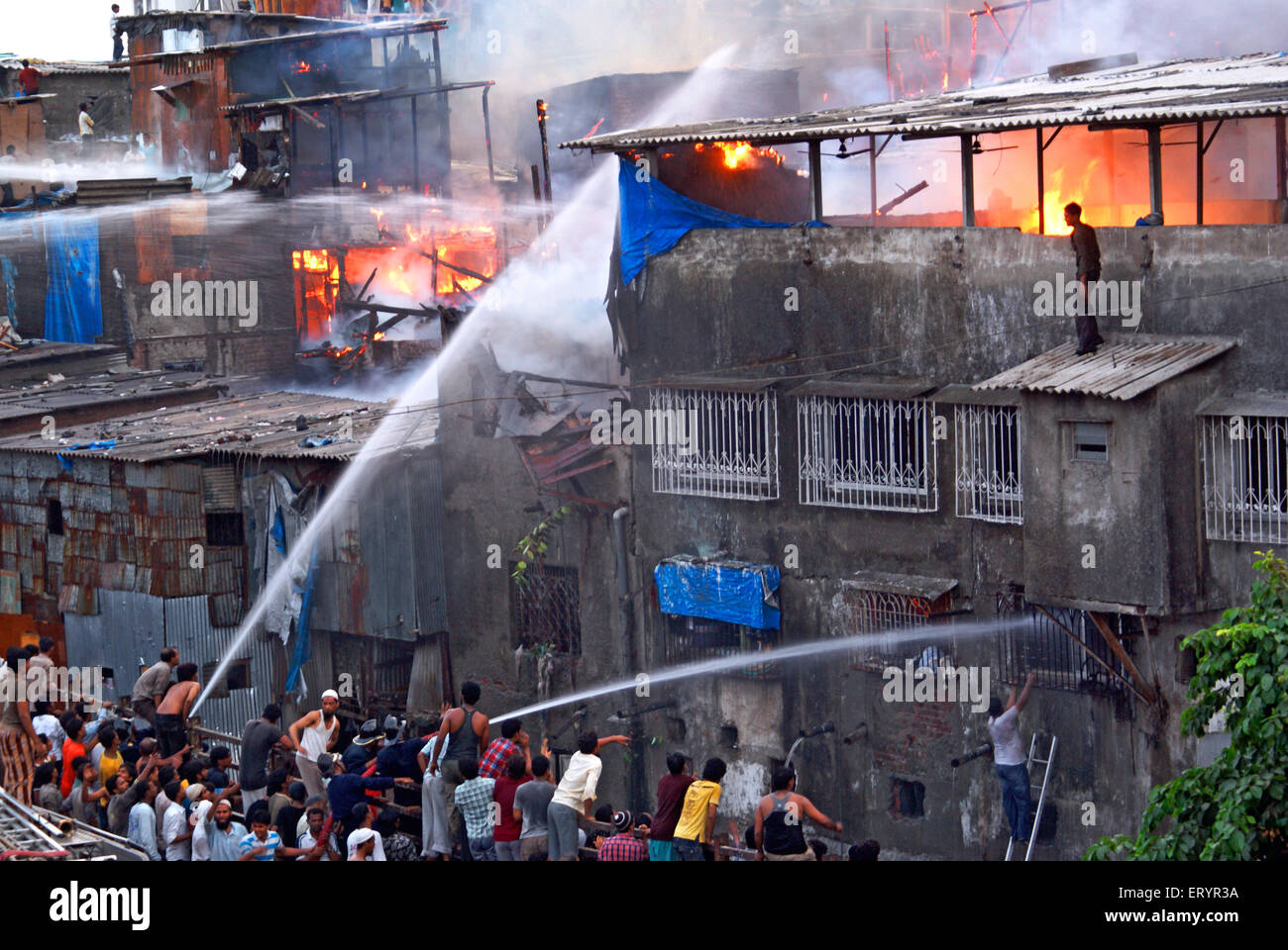 Les pompiers éteindre le feu à l'aide de la plongée dans les bidonvilles de Bandra Behrampada ; ; ; ; Maharashtra Bombay Mumbai Inde 18 juin 2009 Banque D'Images