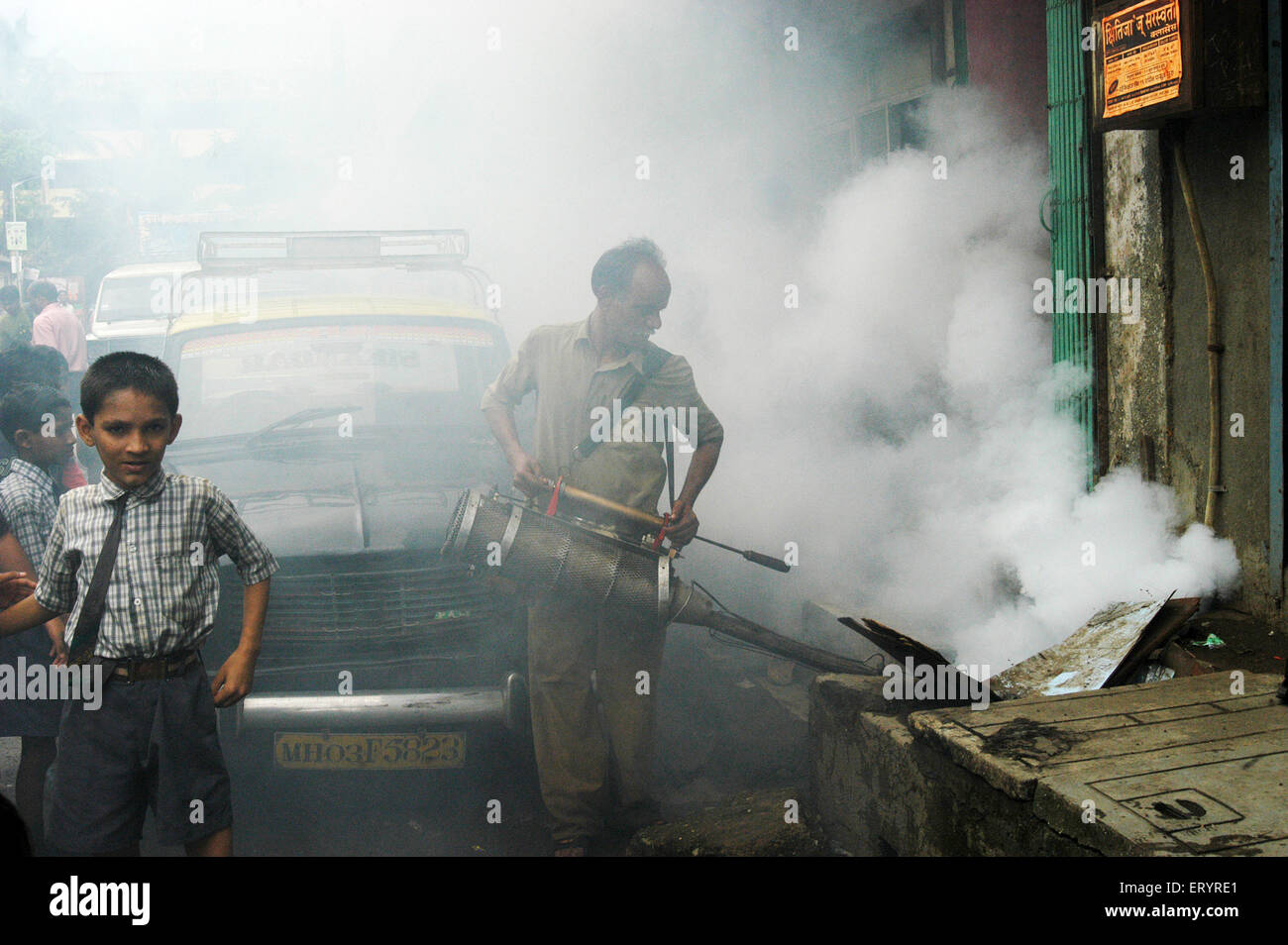 Employé municipal à l'aide de la machine de buée dans lane pour contrôler le paludisme dans la région de Bombay Mumbai Maharashtra ; Inde ; Banque D'Images