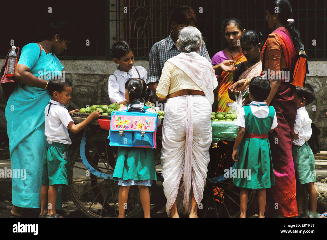 Fille de l'école avec grand-mère l'achat de fruits dans Bombay Mumbai Maharashtra ; Inde ; Banque D'Images