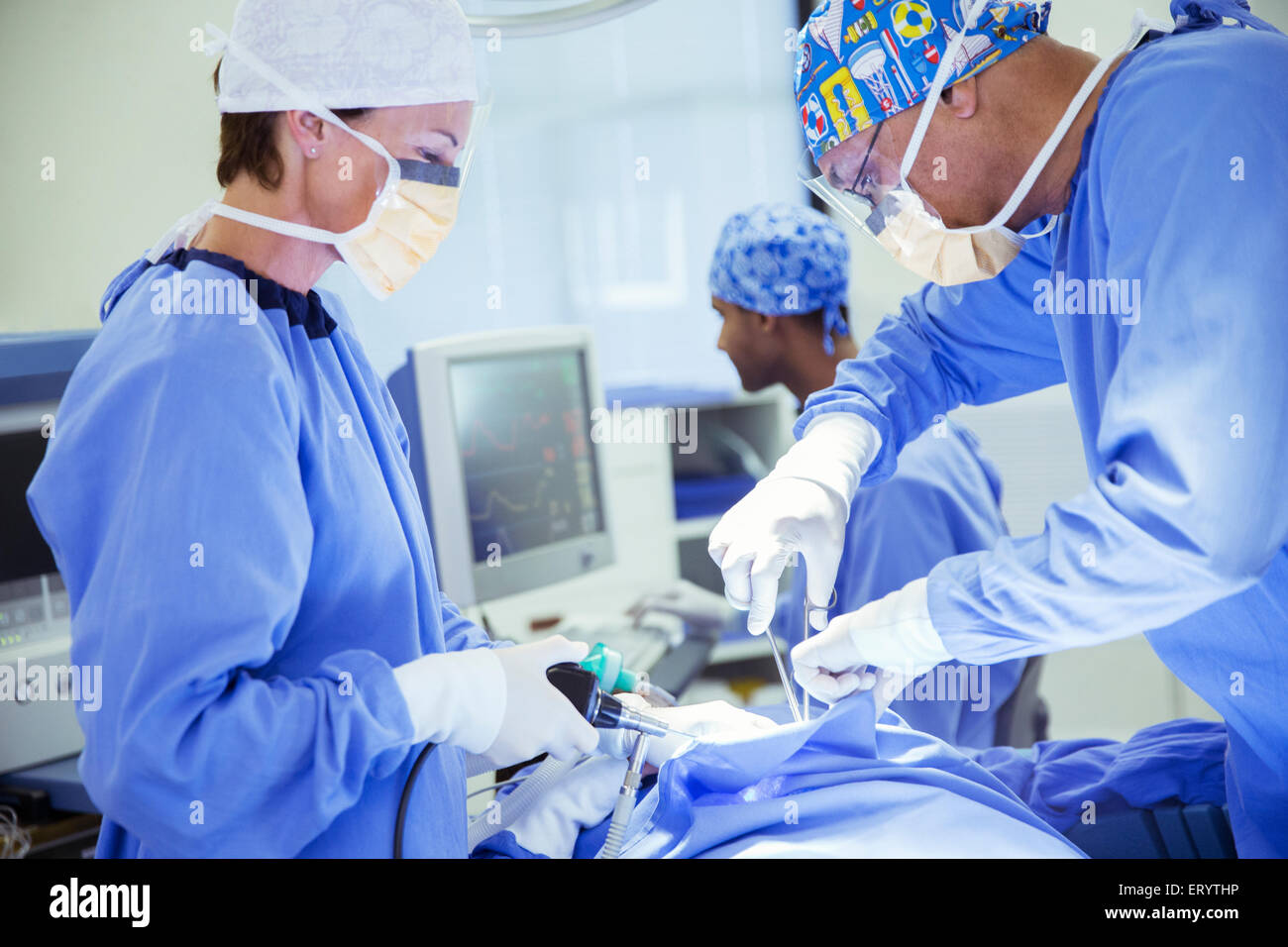 Surgeons performing surgery in operating room Banque D'Images