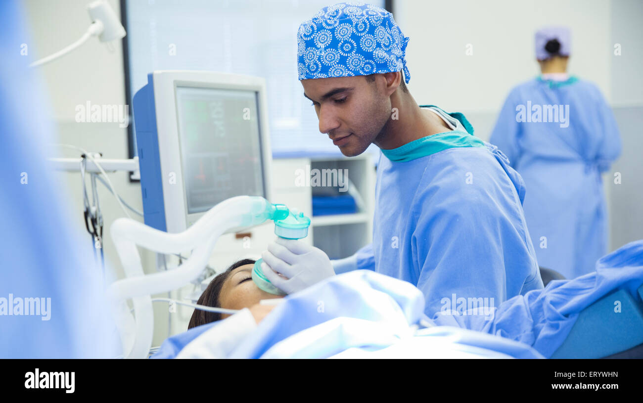 Anesthésiste holding masque à oxygène sur le visage du patient en salle d'opération Banque D'Images