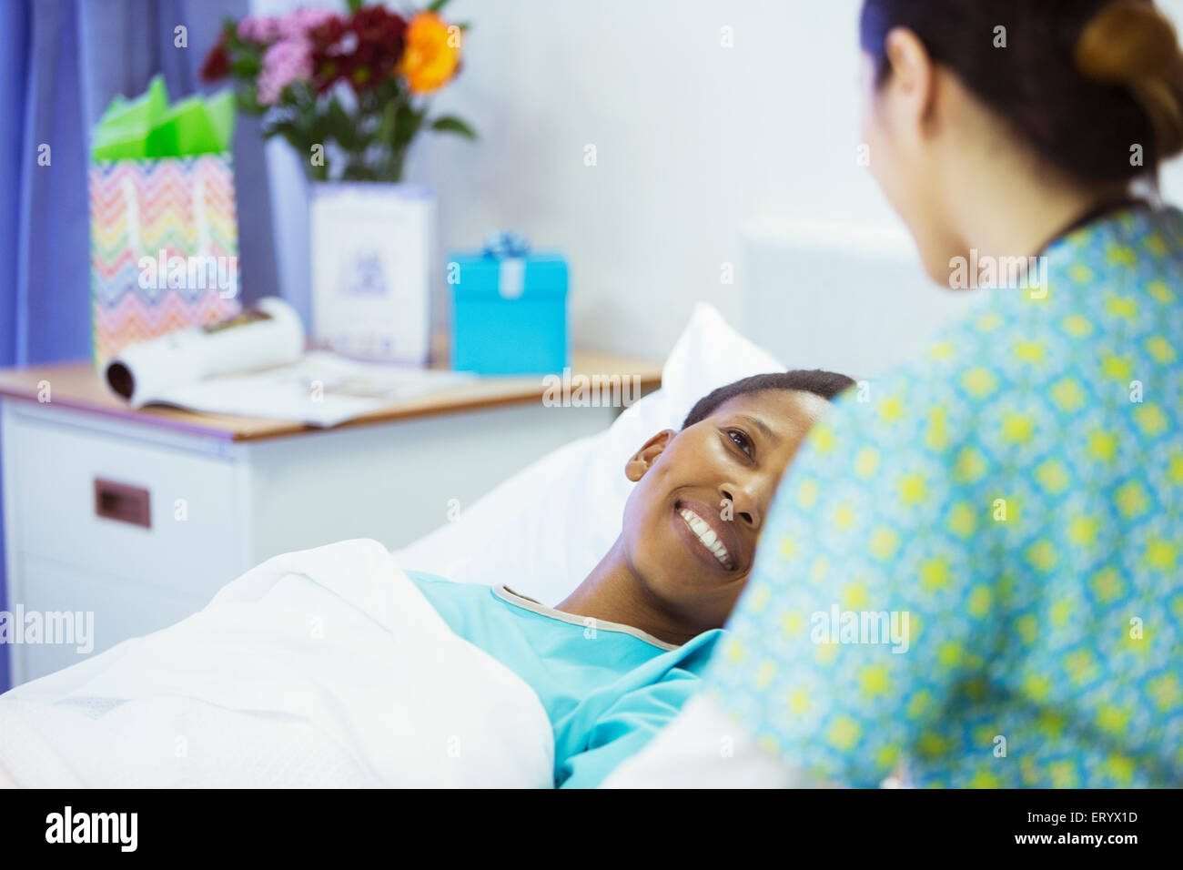 Patient Smiling in hospital bed smiling at nurse Banque D'Images
