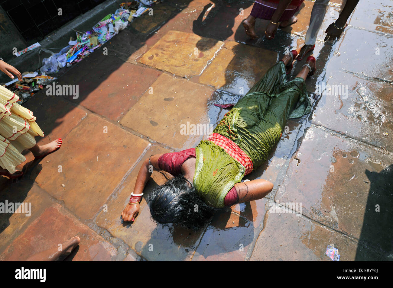 Femme priant, Dandvat Pranam, culte d'obéissance s'étendant sur le trottoir, temple Kalighat Kali, Calcutta, Kolkata, Bengale occidental, Inde, Asie Banque D'Images