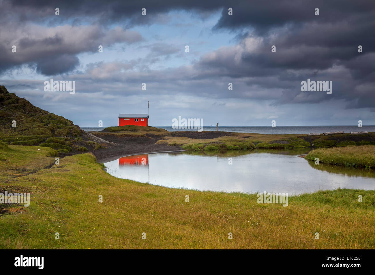 Piscine calme et bâtiment rouge, Skalavik, Isafjordur, Islande, Fjords de l'Ouest Banque D'Images
