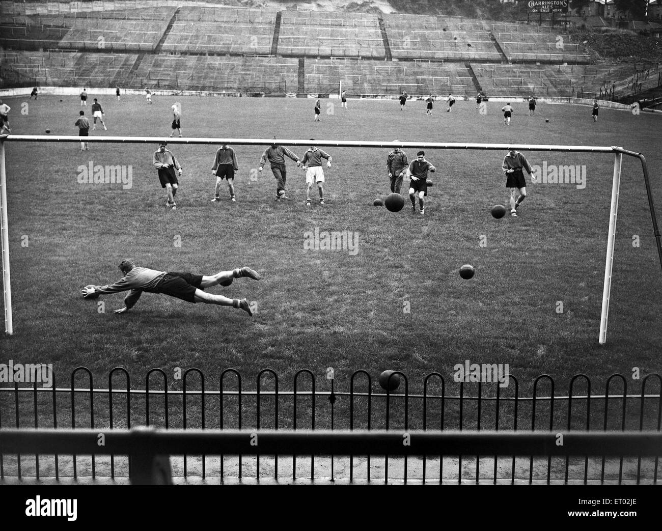 Exercices d'entraînement de l'équipe Charlton Athletic à la vallée. Les exercices de tir gardien Barttram Sam plonge pour essayer d'arrêter l'un des nombre de balles en cours. 9 août 1954. Banque D'Images