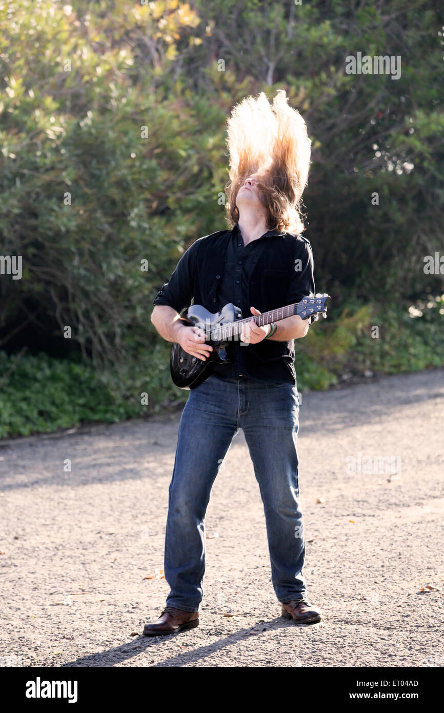 L'homme aux cheveux longs qui joue de la guitare dans la rue Banque D'Images