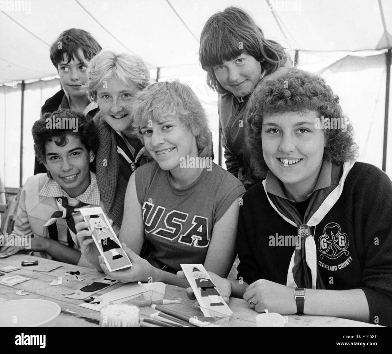 Photographié à la "Cleveland 85' Camp Guides International, tenue à Wynyard Park, près de Wolviston, cette semaine, Laurel Rueter (façade) de l'Illinois, termine un livre marqueur pendant une démonstration d'artisanat vu par Andrea Brackett (front de gauche) du Canada et Wendy Hoffman (avant droit) de l'Illinois, avec le banc arrière filles locales Victoria Jackson de Marske, Elisabeth Smith de Norton, et Shirley Smith de Dharamsala. 3e juillet 1985. Banque D'Images