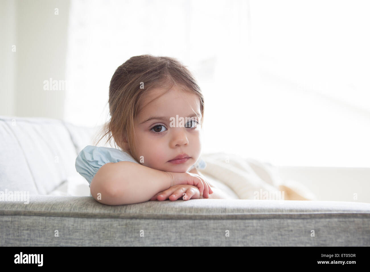 Portrait de jeune fille sérieuse sur canapé Banque D'Images