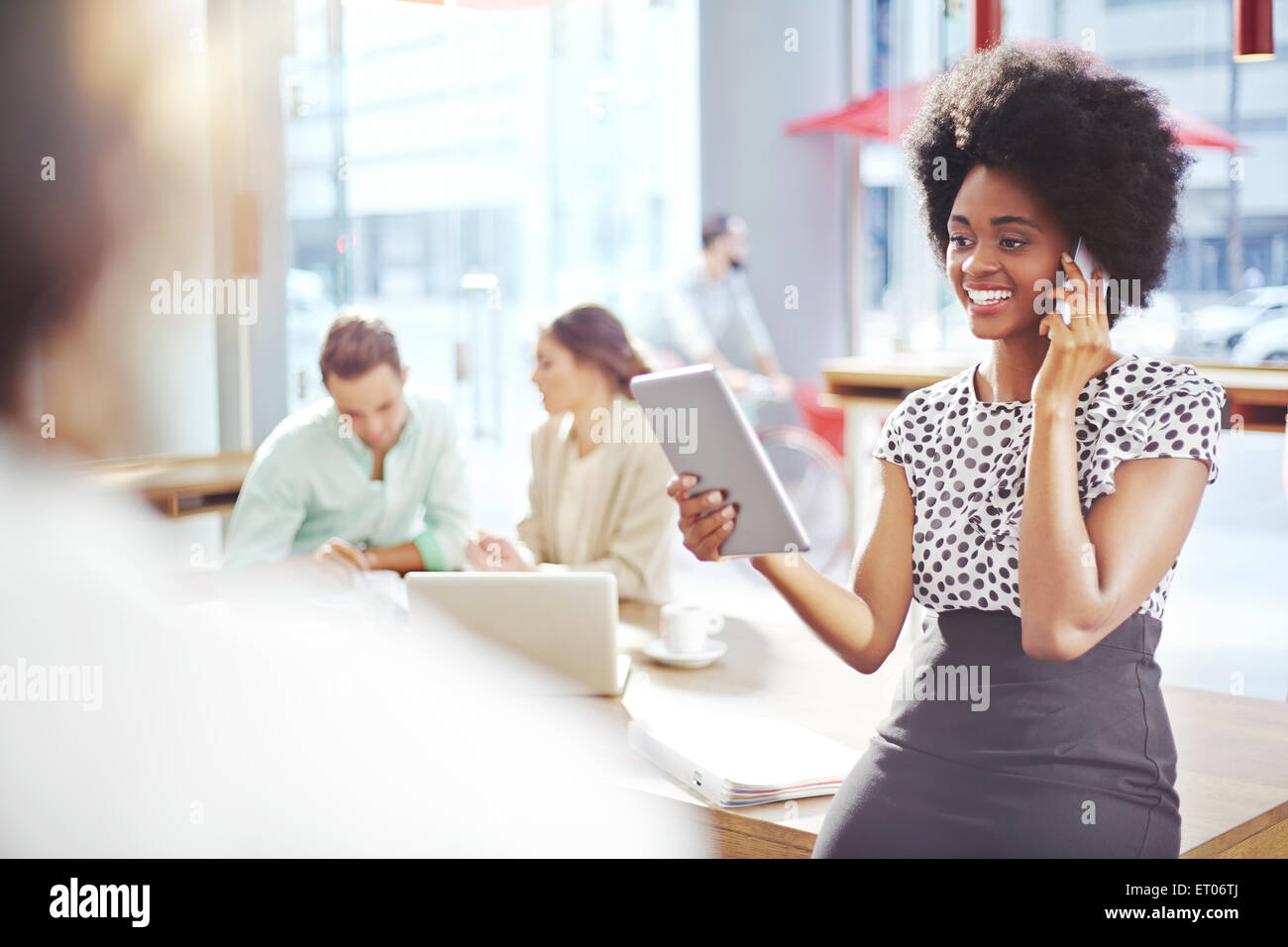 Businesswoman talking on cell phone and using digital tablet Banque D'Images