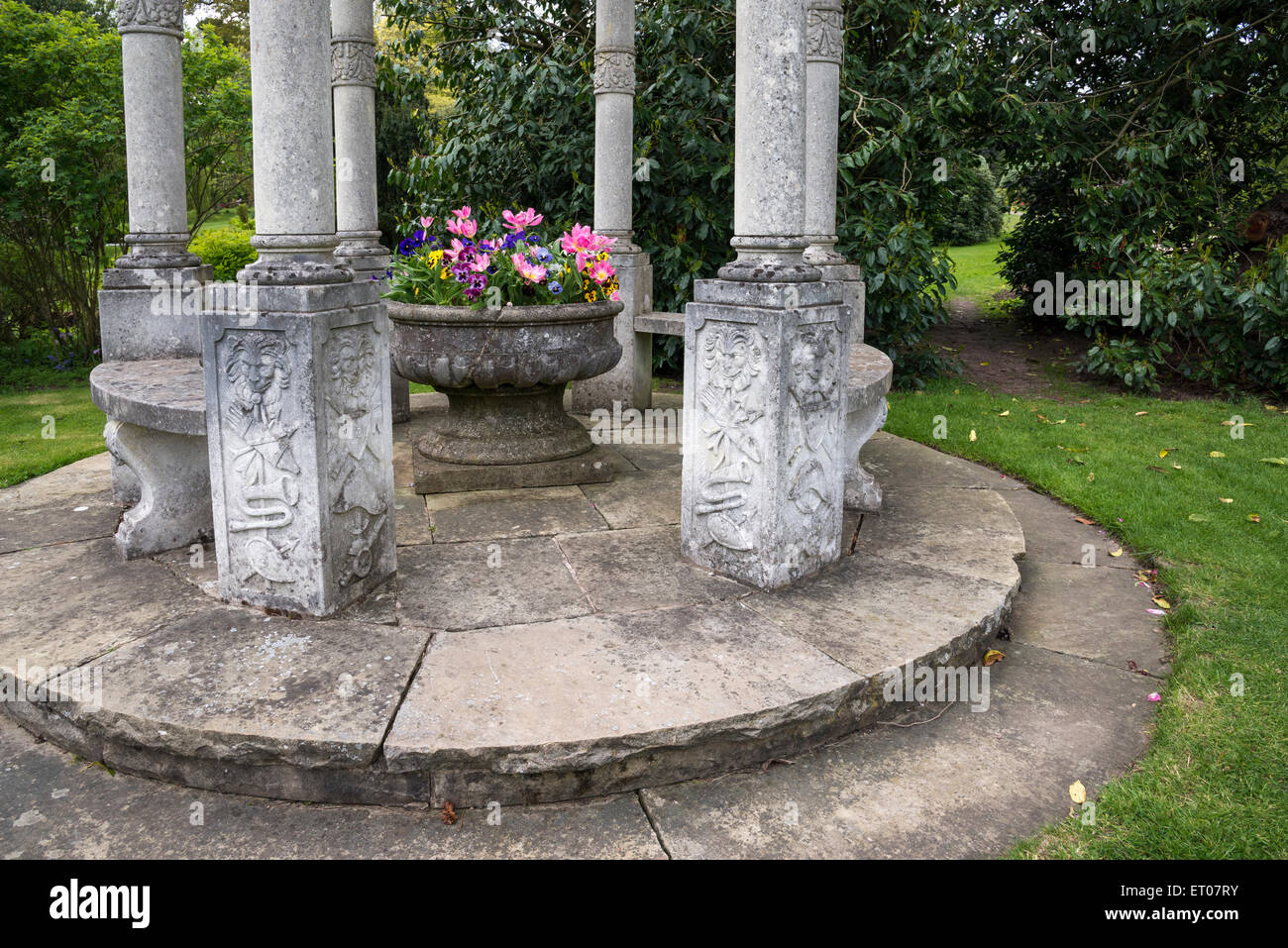 Une urne décorative planté de fleurs de printemps avec un jardin de pierres à Cholmondeley Castle Gardens, Cheshire. Banque D'Images