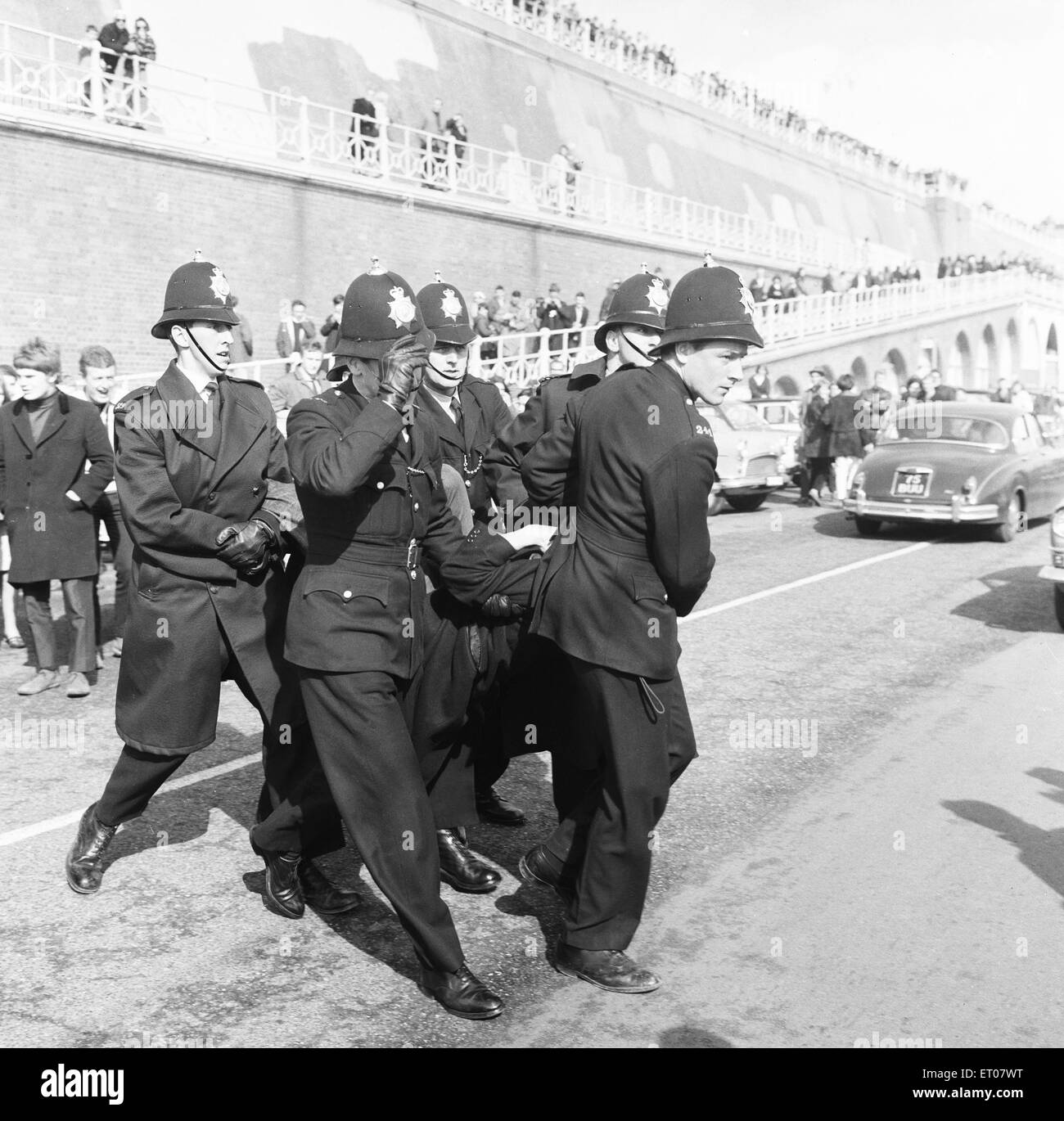 Un jeune souffre d'une des agents de police à la suite d'un incident sur Clacton front de mer. Au cours des week-end de Pâques 1964 plusieurs échauffourées entre Mods et Rockers ont éclaté dans la ville balnéaire d'Essex. 30 Mars 1964 Banque D'Images