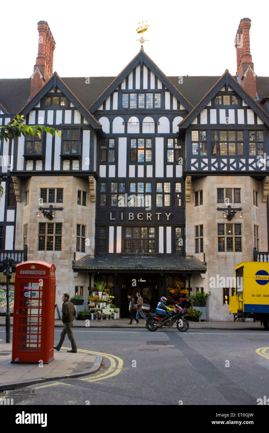 Tudor maisons , Liberty , cabine téléphonique rouge , camion jaune , Londres , Angleterre , Royaume-Uni Banque D'Images