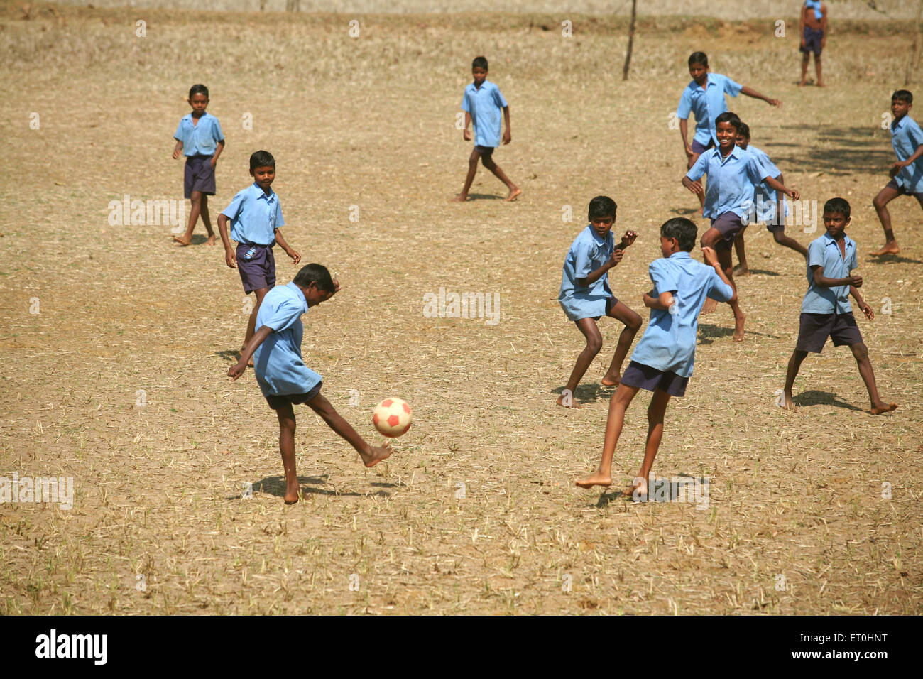 Garçons d'école, uniforme d'école, jouer au football, terrain de village, Jharkhand, Inde, sport rural indien Banque D'Images