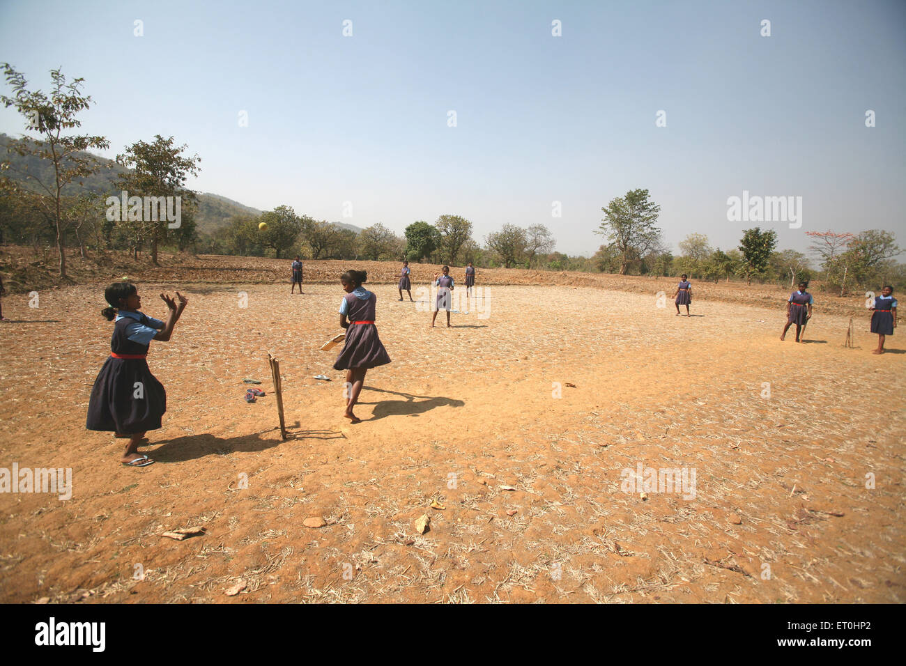 Filles d'école, uniforme scolaire, jouer au cricket, terrain de village, Jharkhand, Inde, sports ruraux indiens Banque D'Images