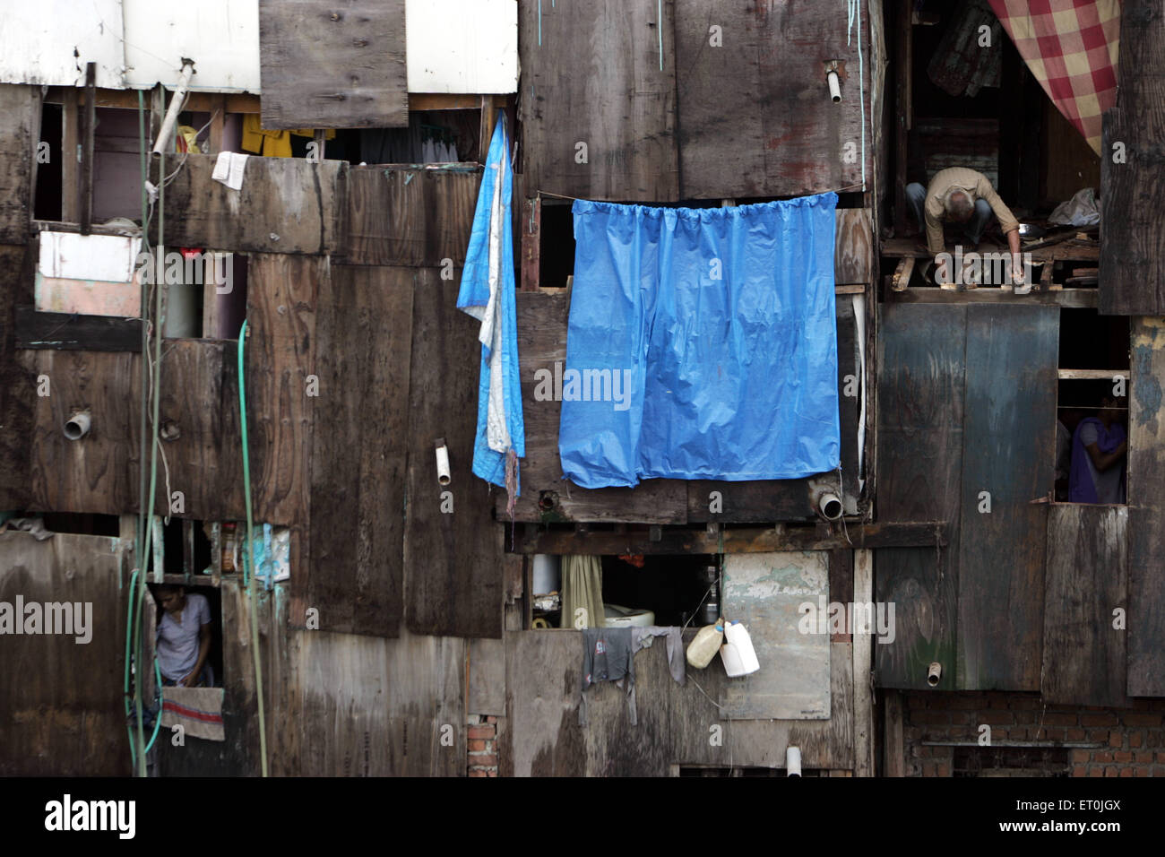 Un vieil homme peut être vu assis à une porte ; Behrampada à Bandra taudis ; Bombay Mumbai Maharashtra ; Inde ; Banque D'Images