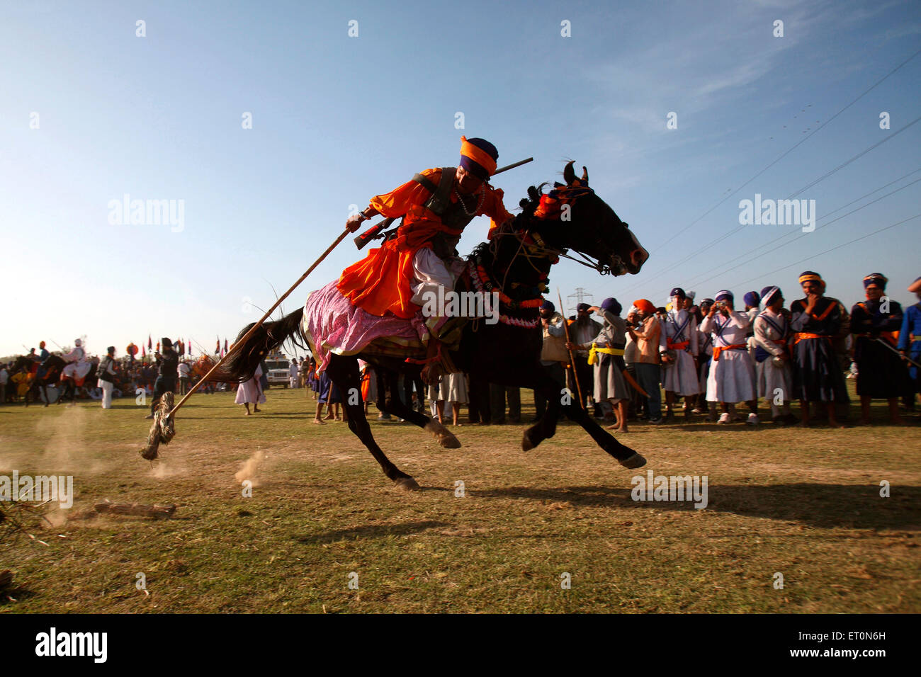 Guerrier Sikh Nihang ou exerçant son spear faisant tente de stabiliser l'équitation sur festival Anandpur sahib Road Hola punjab inde Banque D'Images