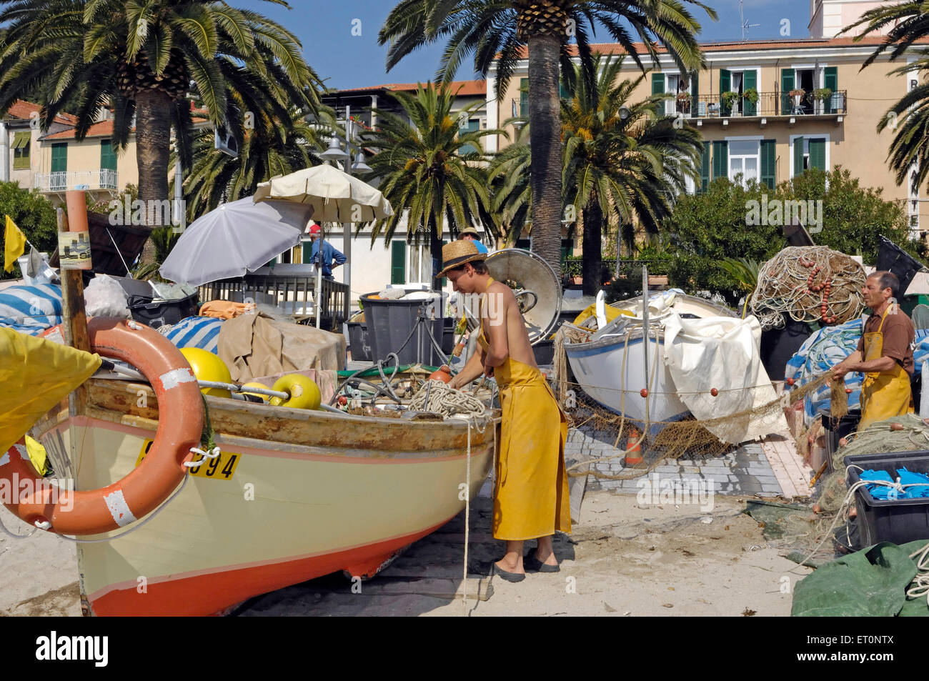 Les pêcheurs avec un bateau de pêche sur la plage de Noli, Riviera di Ponente, Ligurie, Italie Banque D'Images