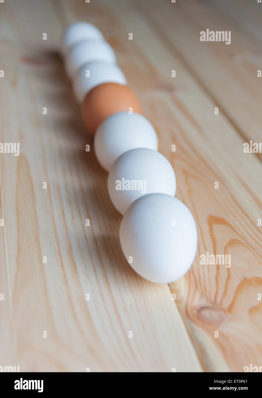 Les œufs de couleur différente se coucher sur une table en bois Banque D'Images