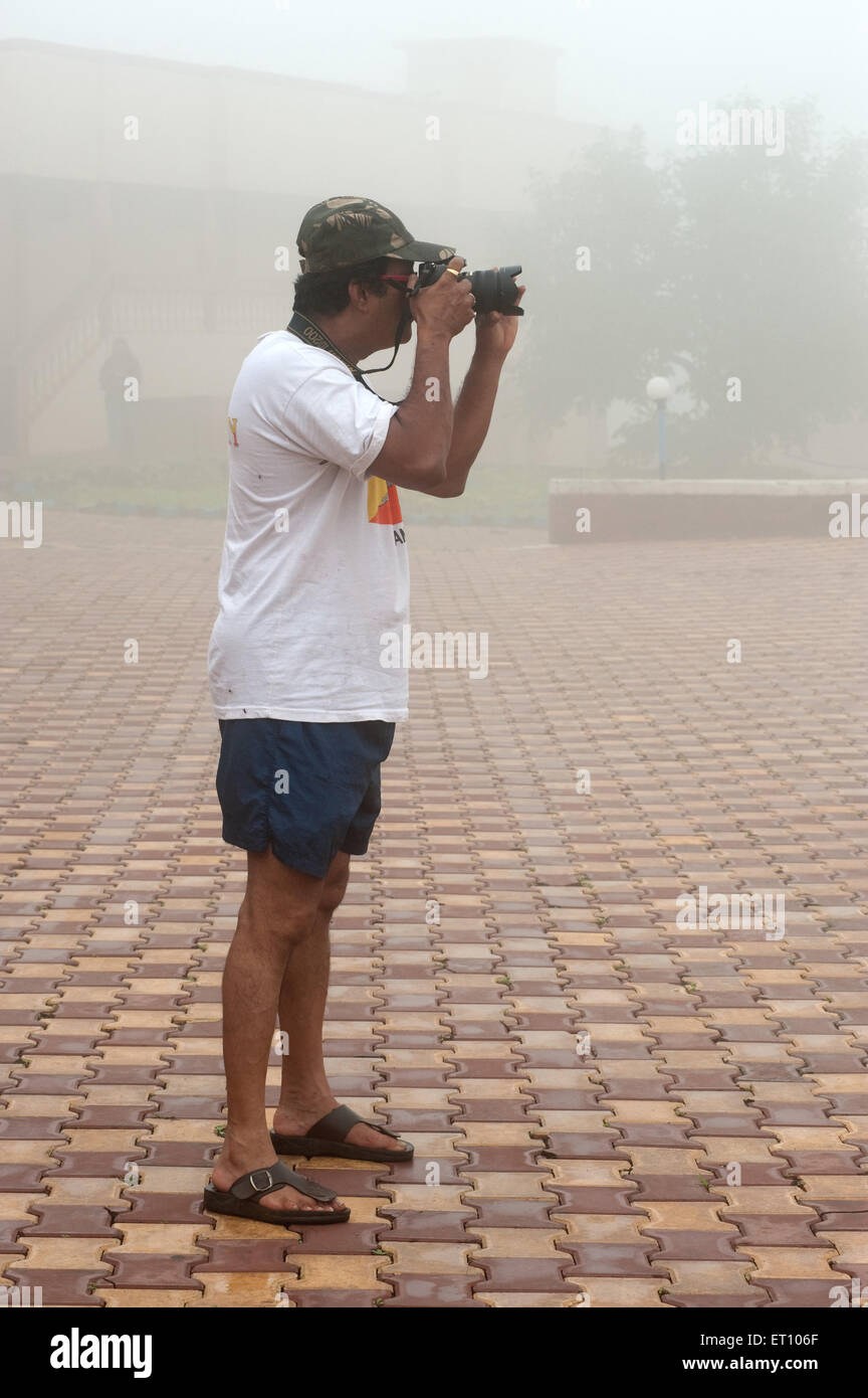 Man taking photograph in mist ; Malshej Ghat ; Thane Maharashtra Inde ; 2010 ; Banque D'Images