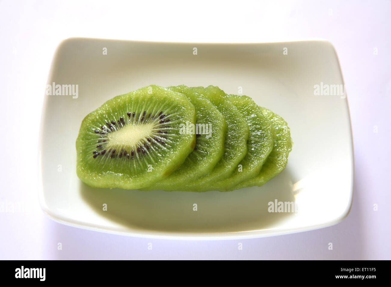 Fruit, tranches de kiwi dans le bac sur fond blanc Banque D'Images