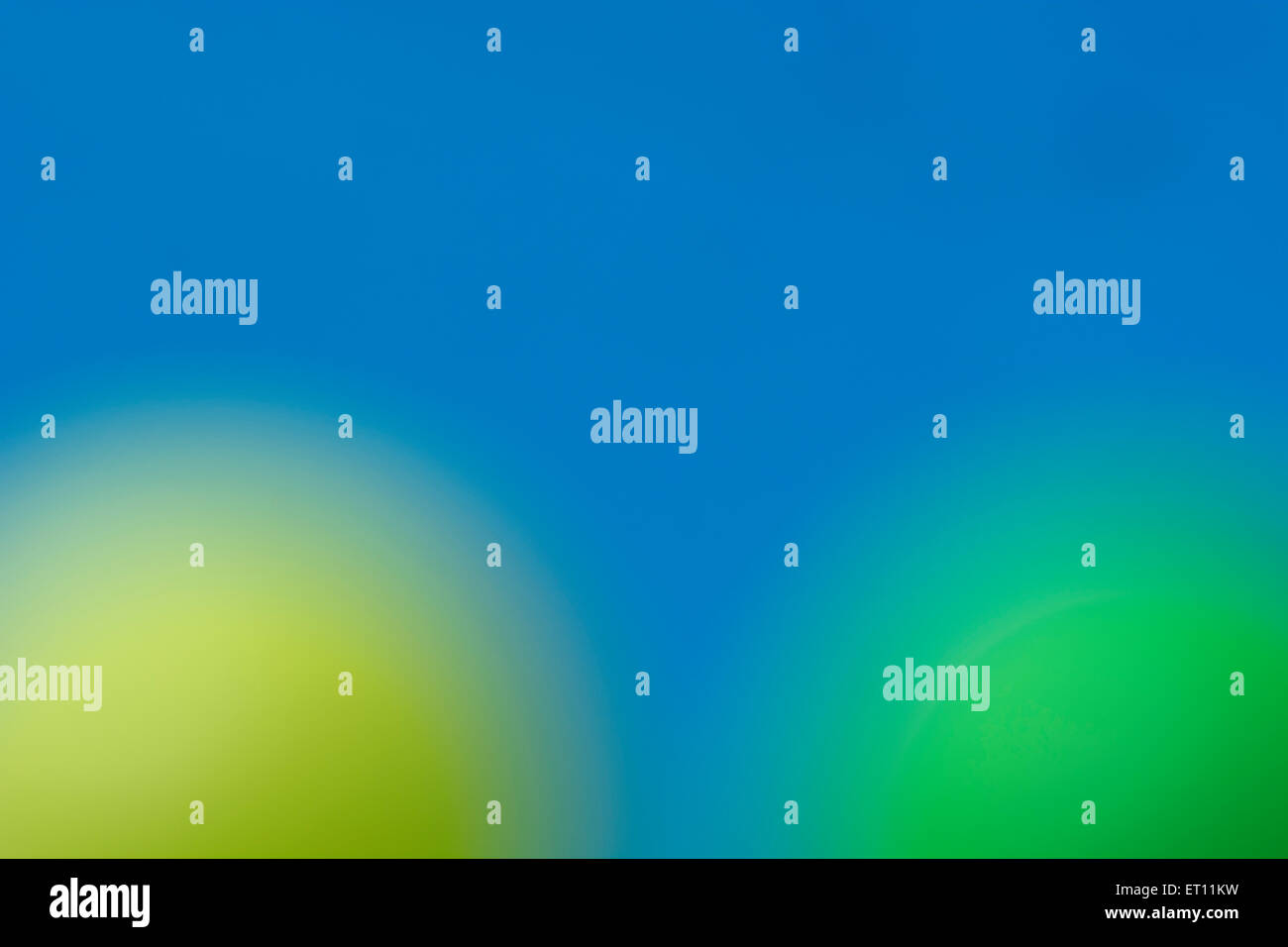 Abstrait, hors focale, sphères jaunes et verts contre fond bleu ciel. Banque D'Images