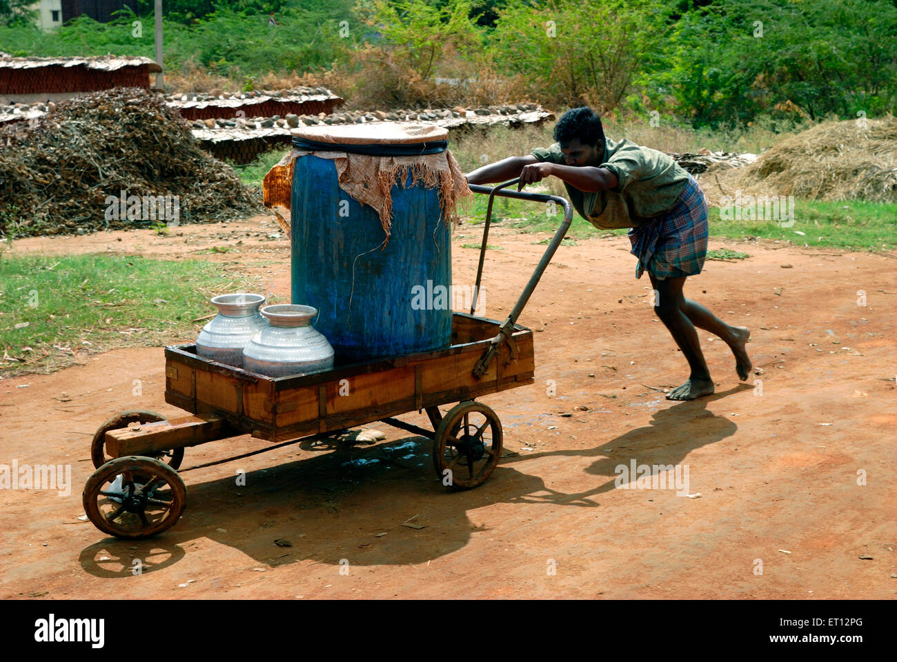 Homme poussant chariot à main avec des pots d'eau ; Tamil Nadu ; Inde Banque D'Images