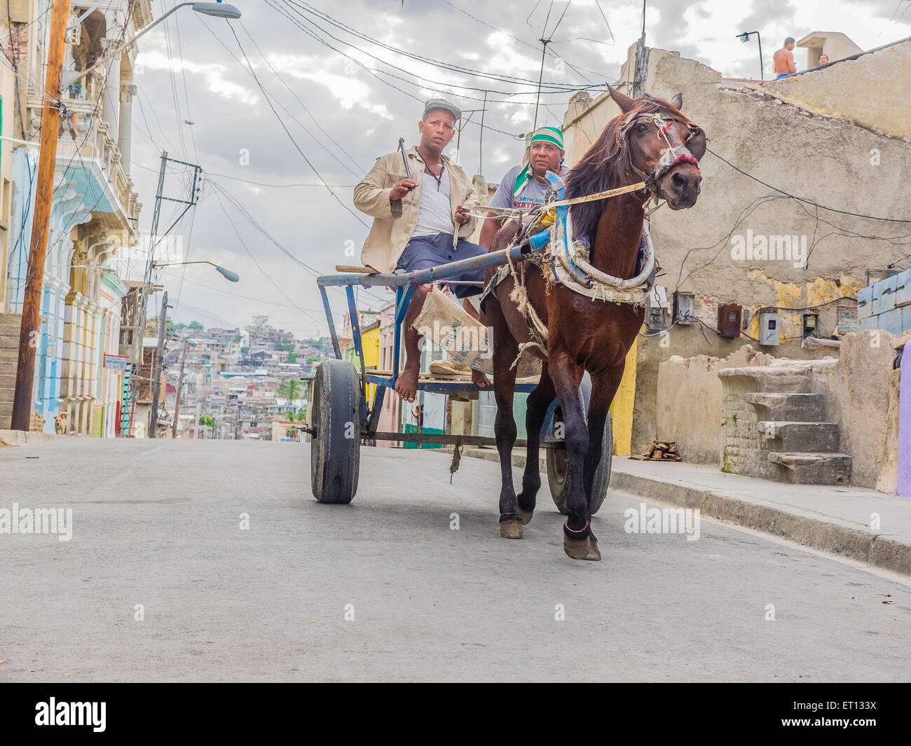Deux hommes travailleurs cubains dans leur trajet en calèche dans les rues de Santiago de Cuba. Banque D'Images