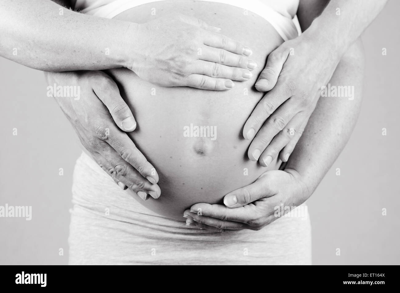 Les mains des parents faire un coeur sur le ventre des mères Banque D'Images