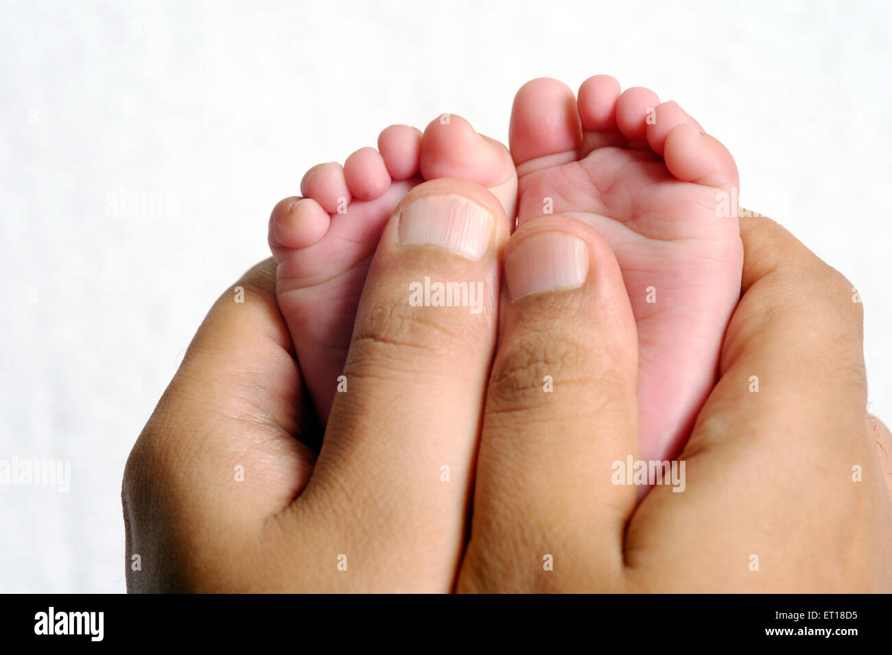 Père holding née pieds bébé MR# 736J&LA Banque D'Images