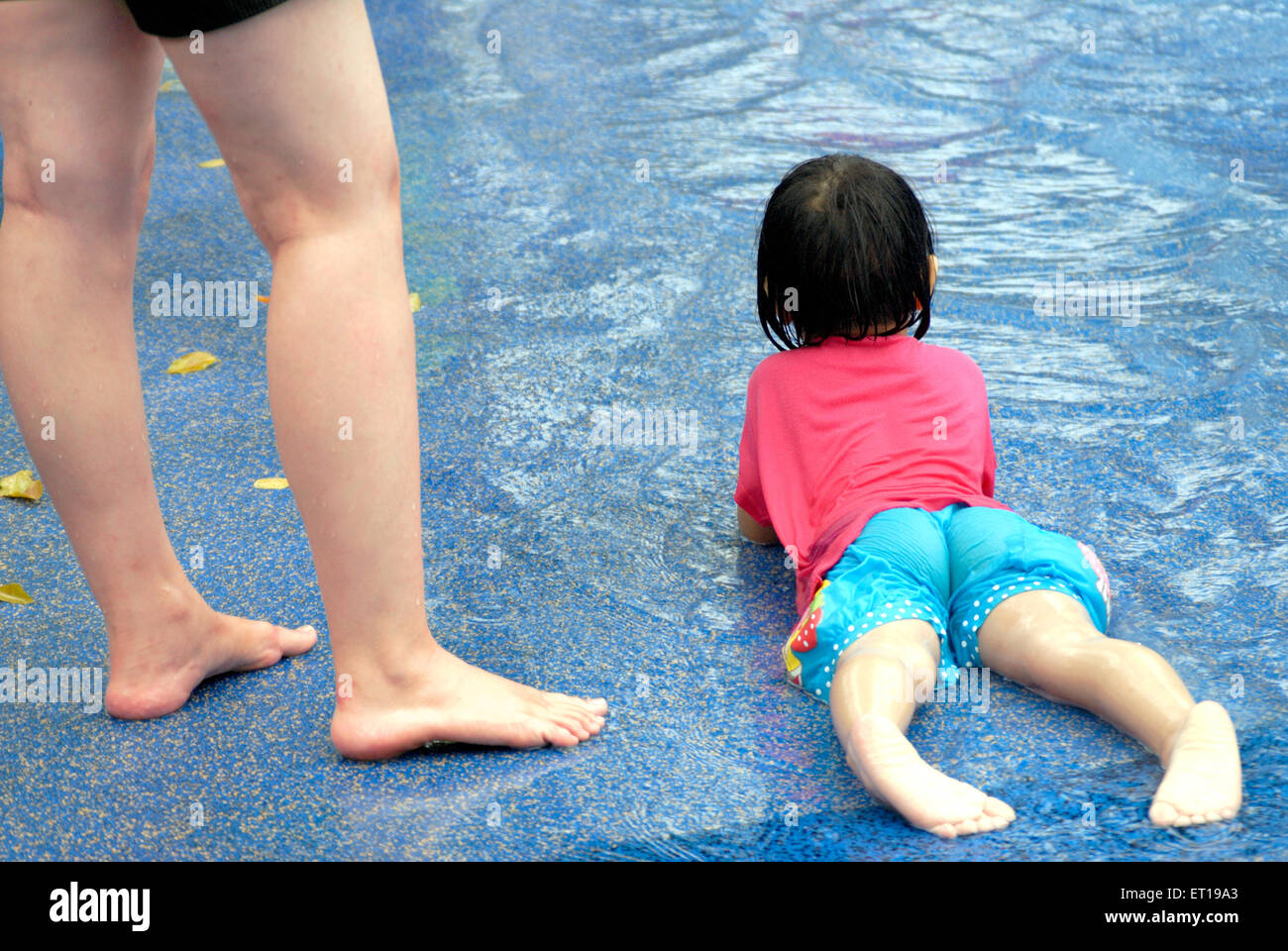 Dans l'eau bénéficiant d'enfant auprès de sa mère les jambes Banque D'Images