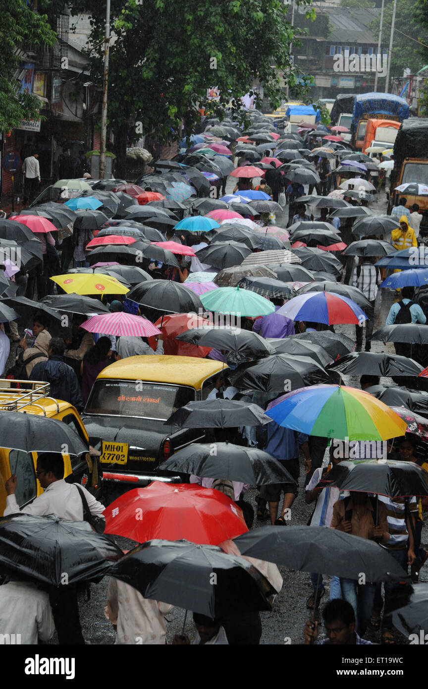 Les gens qui marchent dans la rue bondée avec parapluie colorés Mumbai Maharashtra Inde Banque D'Images