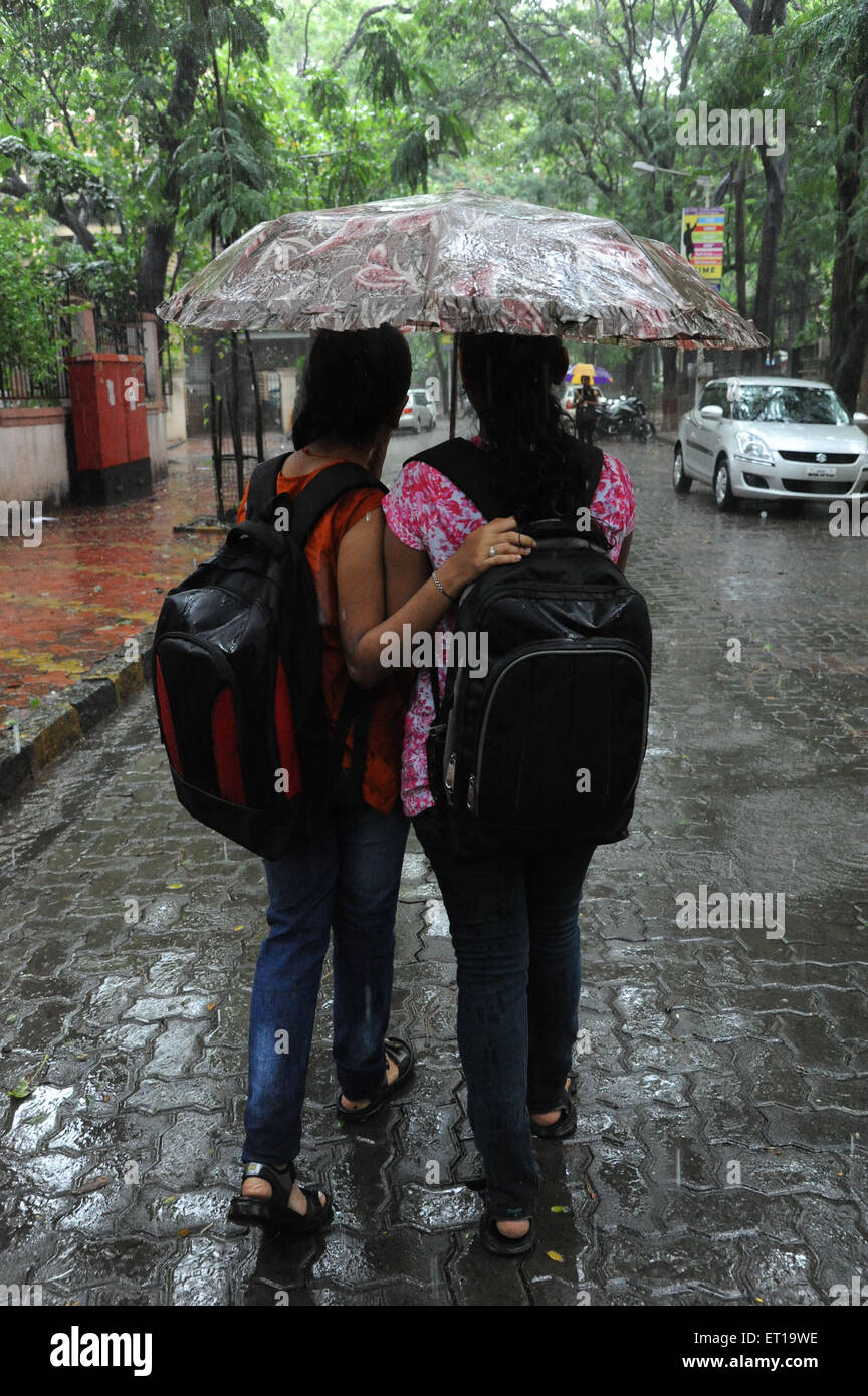 Girls holding d'un parasol marche sur rue pavée, dans la pluie monsieur# 364 Banque D'Images