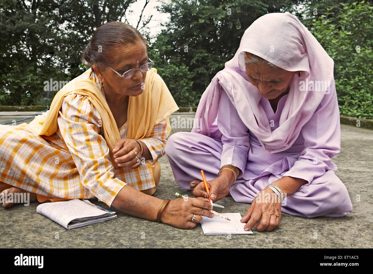 Enseignement bénévole vieille dame d'écrire le programme d'alphabétisation des adultes l'initiative socio-économique a commencé par l'ONG Organisation Chinmaya Banque D'Images