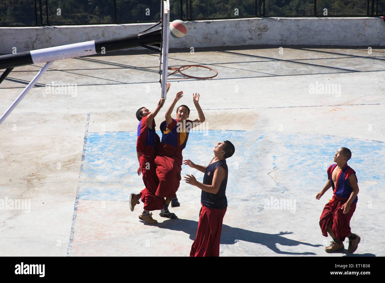 Moines tibétains portant des vêtements de couleur marron jouant au basket-ball sur le terrain ; Dulanji ; l'Himachal Pradesh en Inde ; Banque D'Images