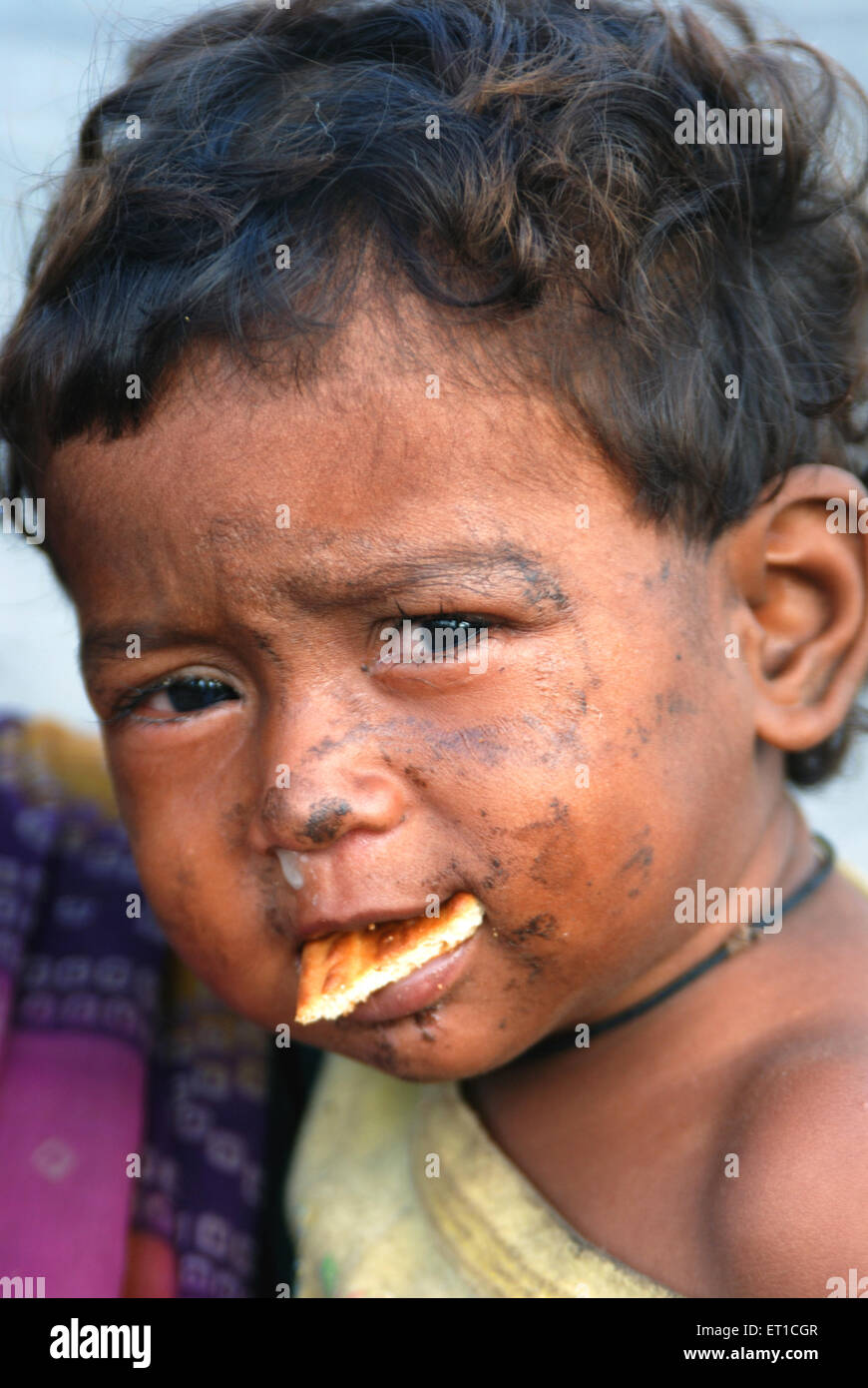 Pauvre garçon mangeant biscuit ; Bombay ; Mumbai ; Maharashtra ; Inde Banque D'Images