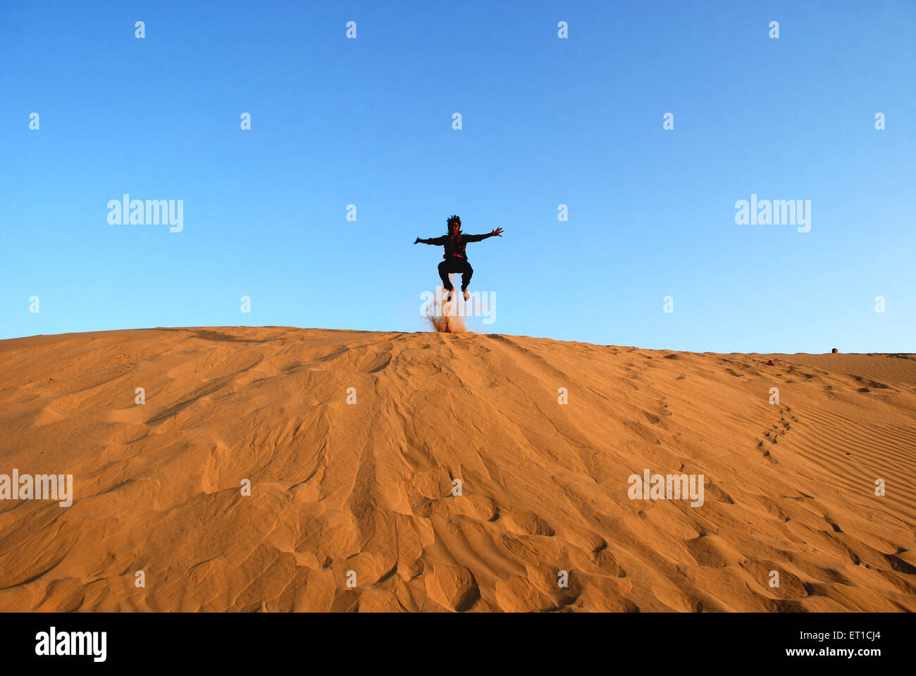 Garçon sautant au dessus des dunes de Khuri Khuhri ; ; ; ; Inde Rajasthan Jaisalmer Banque D'Images