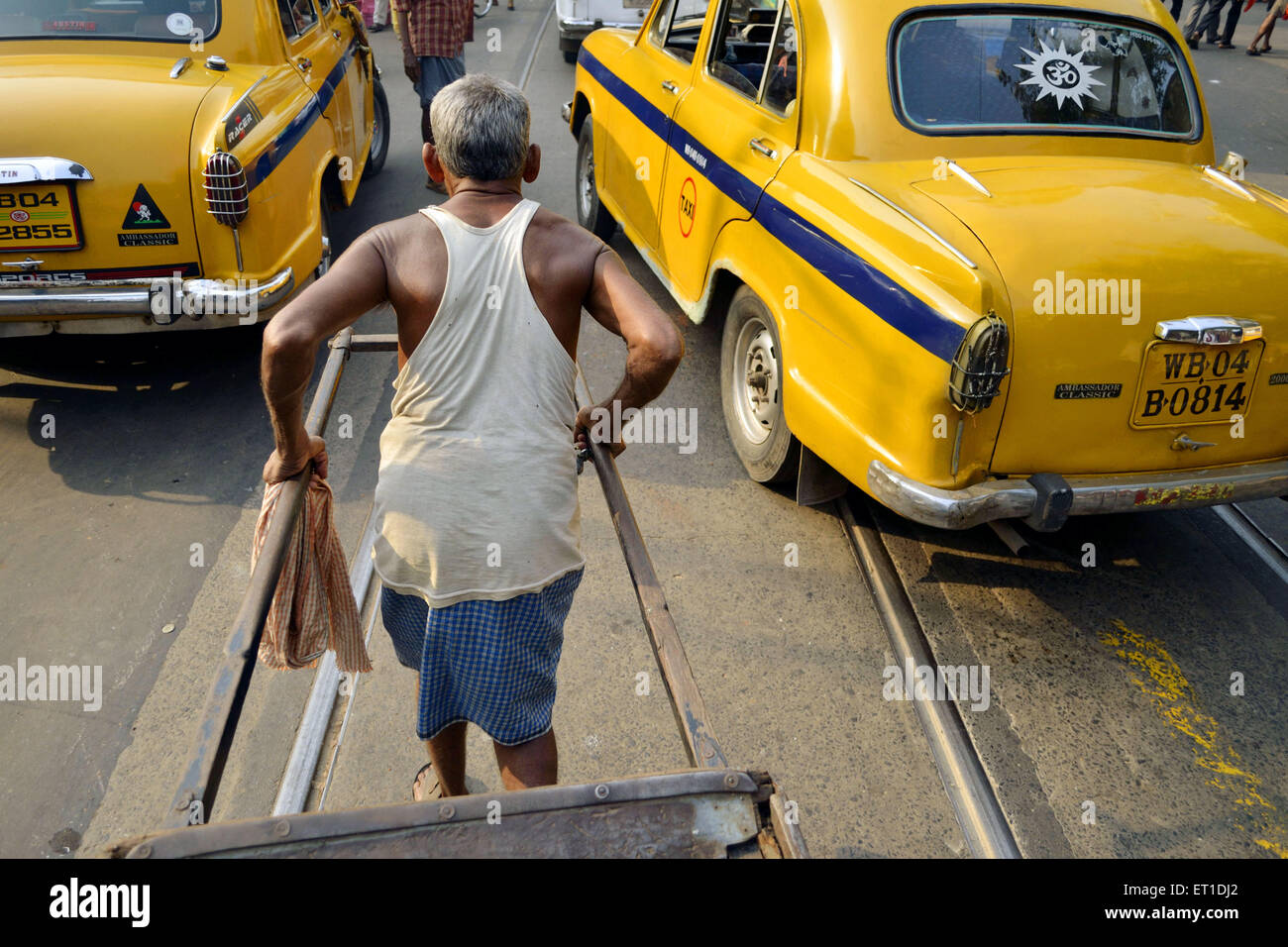 L'homme tirant part pousse-pousse sur la route de l'Ouest Bengale Asie Inde Kolkata Banque D'Images