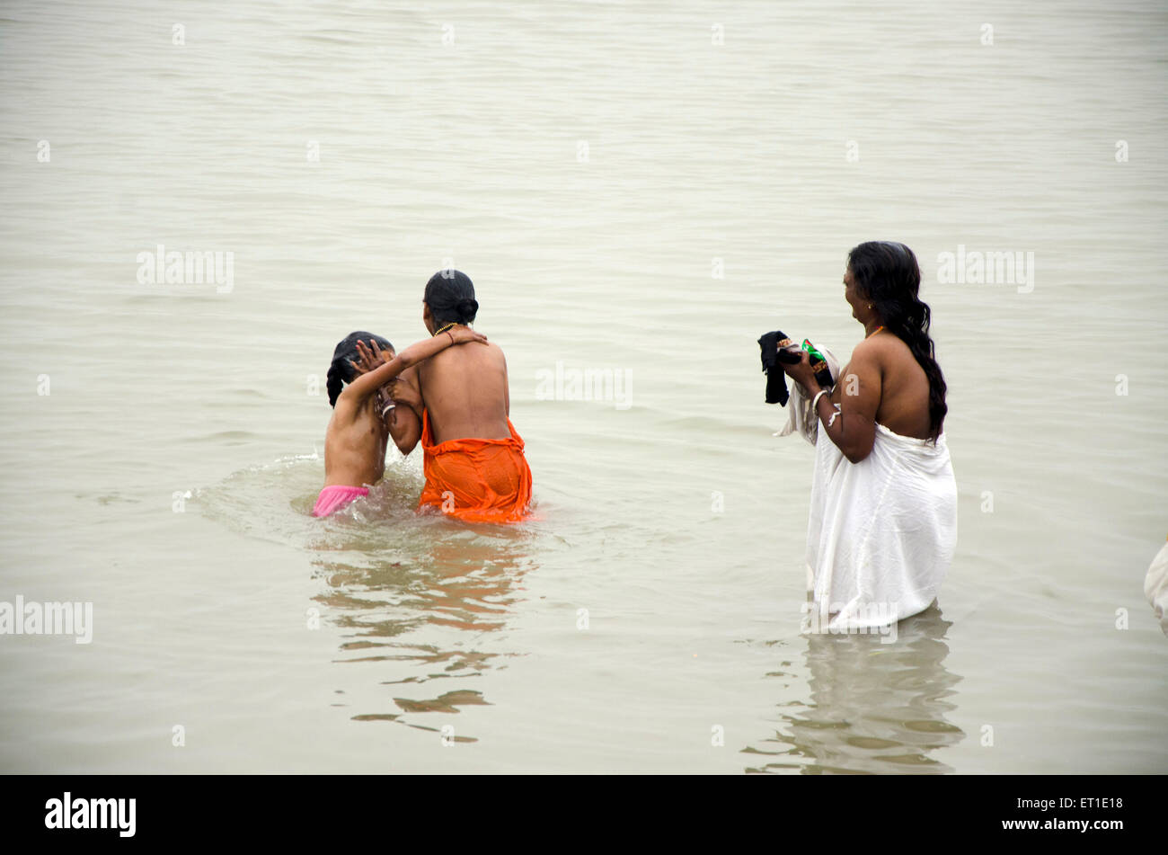 Femme avec fille se baigner dans la rivière Hooghly Kolkata West Bengale Inde Asie Banque D'Images