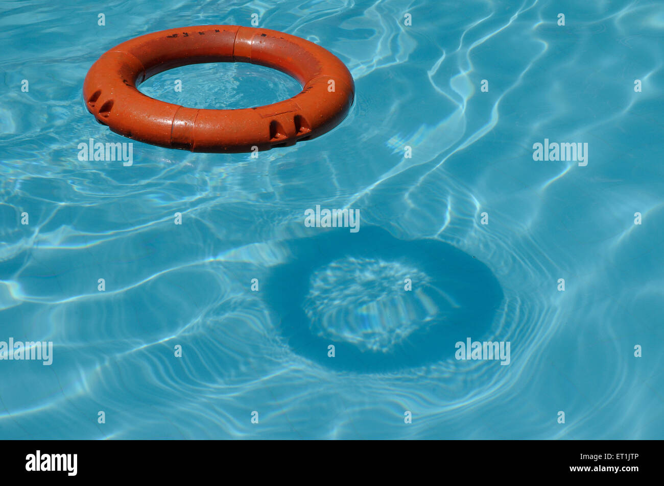 Anneau de sauveteur flottant sur l'eau bleue dans la piscine Banque D'Images