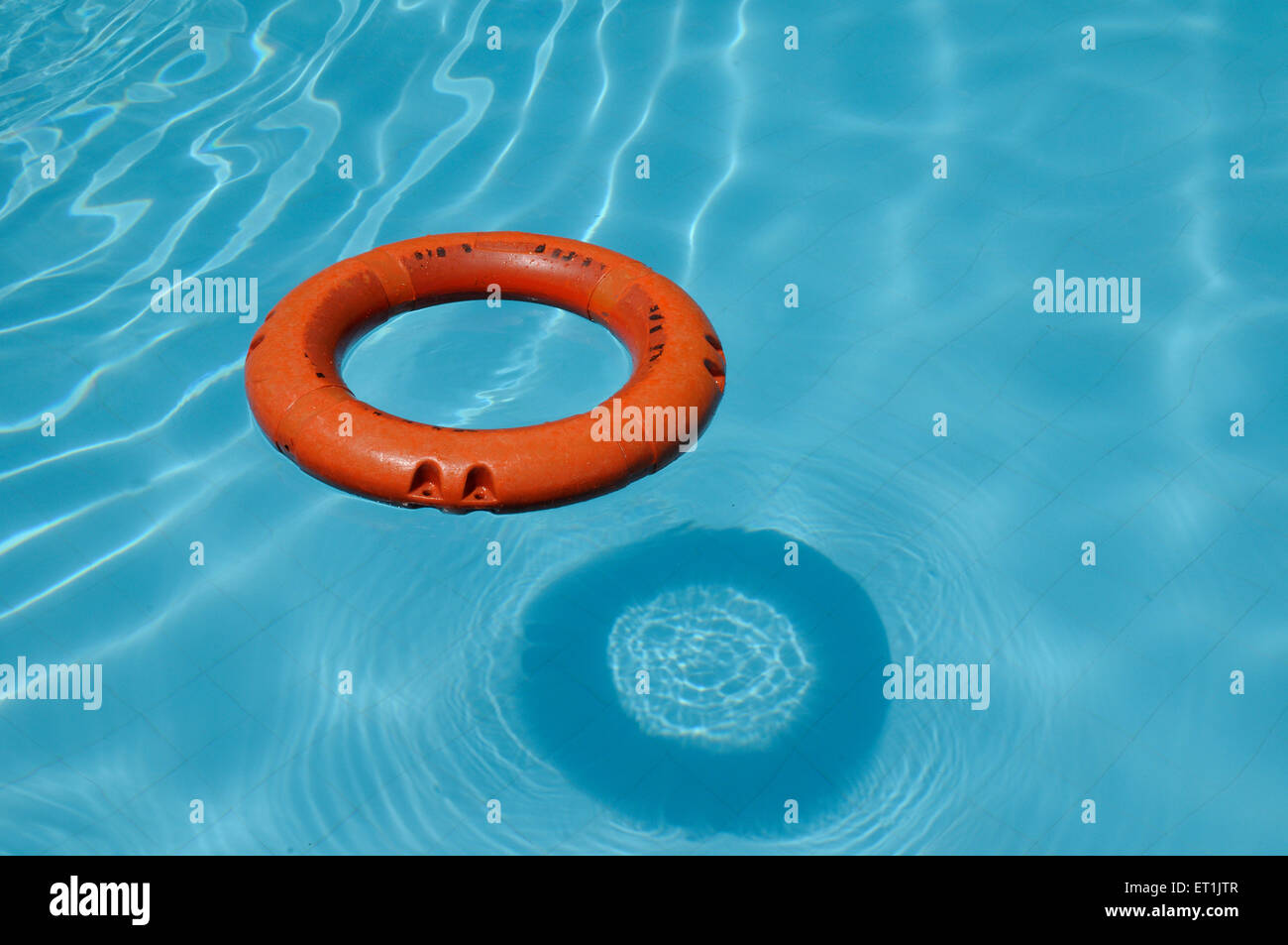 Anneau de sauveteur flottant sur l'eau bleue dans la piscine Banque D'Images