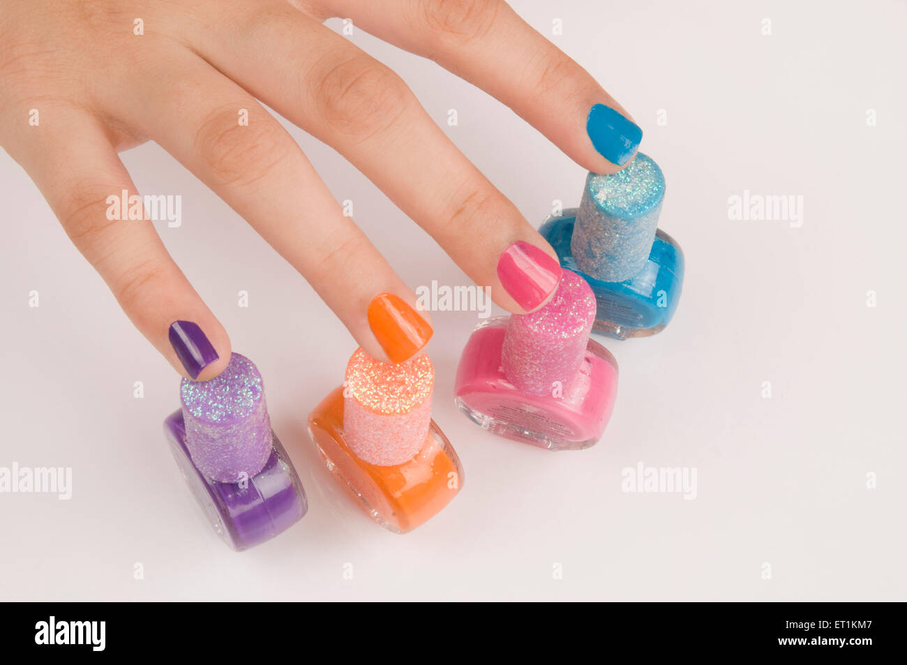 doigts avec des bouteilles de vernis à ongles de différentes couleurs Banque D'Images