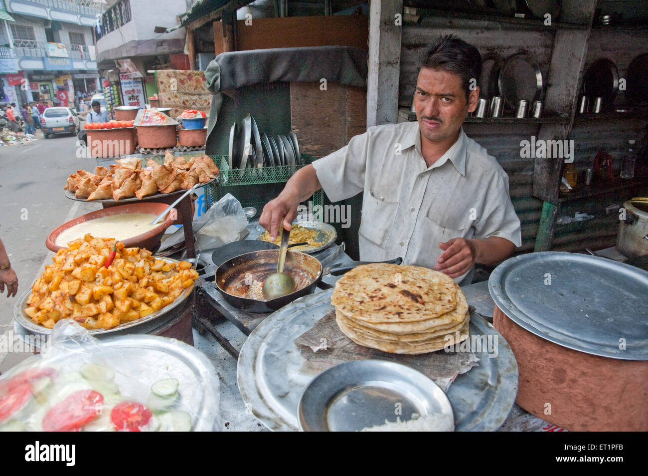 Homme cuisinant sur le bord de la route magasin de nourriture , Uttarakhand , Inde , Asie Banque D'Images