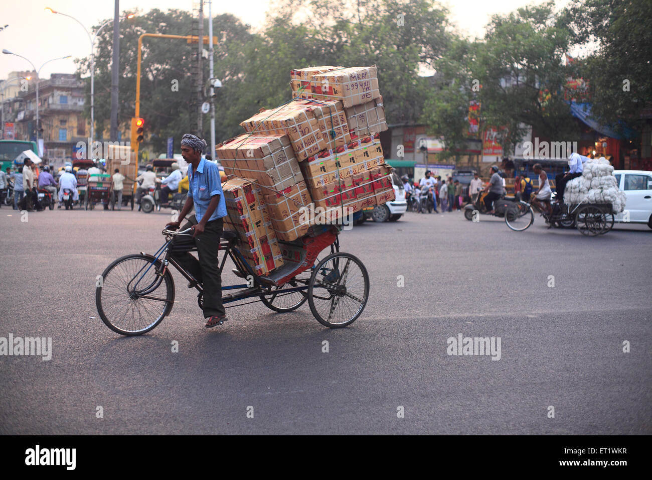 Les travailleurs de pousse-pousse tirer la panier chargés de marchandises à Delhi Banque D'Images
