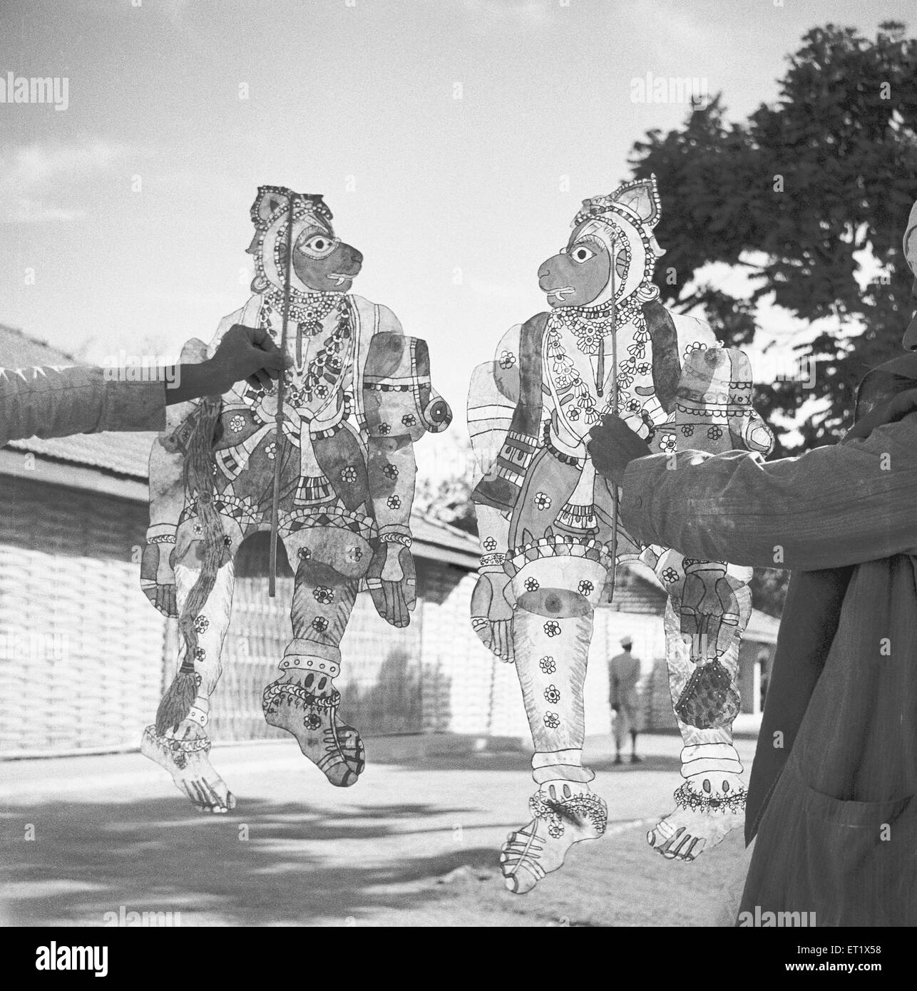 Les hommes affichant des marionnettes en cuir peint transparent le théâtre d'Ombres ; divertissement ; Hallare ; village ; Mysore Karnataka Banque D'Images