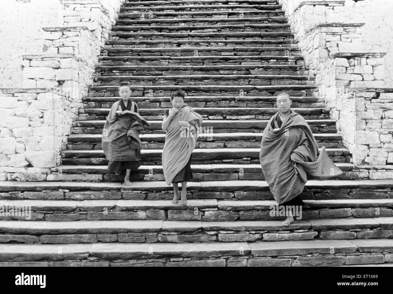 Jeunes moines descendent les marches de l'ancien monastère ; Dzong de Paro au Bhoutan ; Banque D'Images