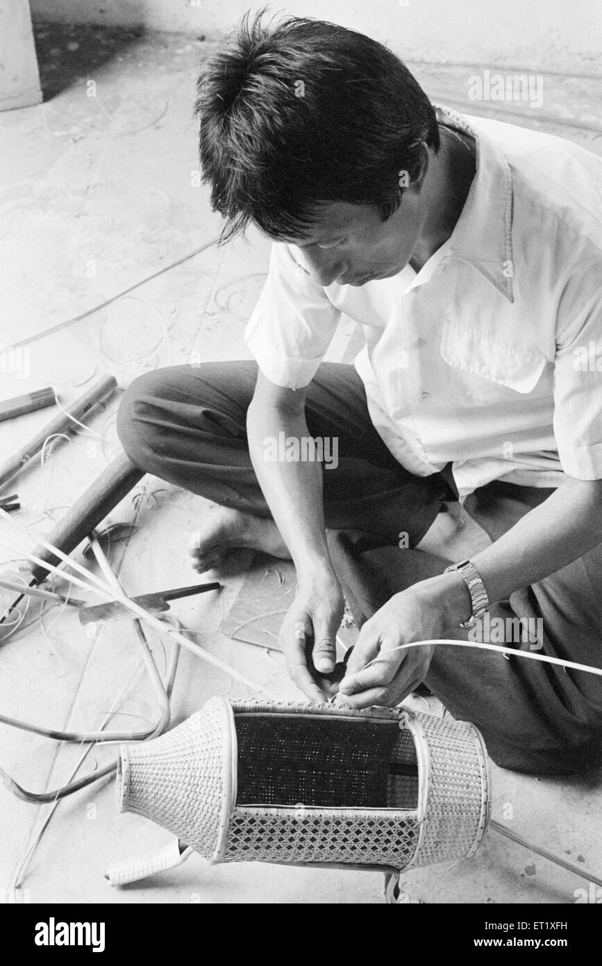 Membre de la tribu Adi travaillant sur le bambou ware ; l'Arunachal Pradesh, Inde 1982 ; Banque D'Images
